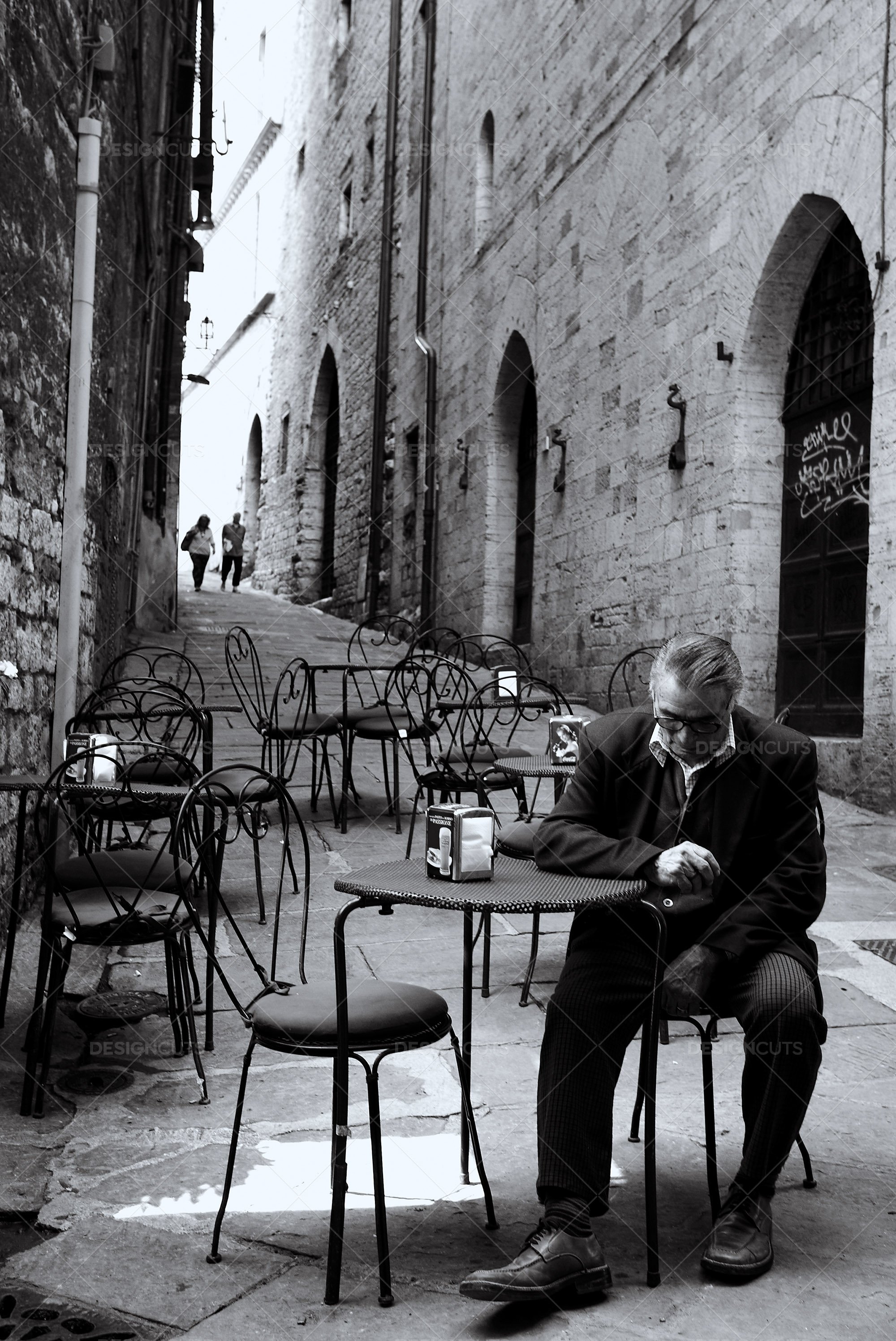 Well Dressed Man Sits Outside At Cafe In Old Italian Alley