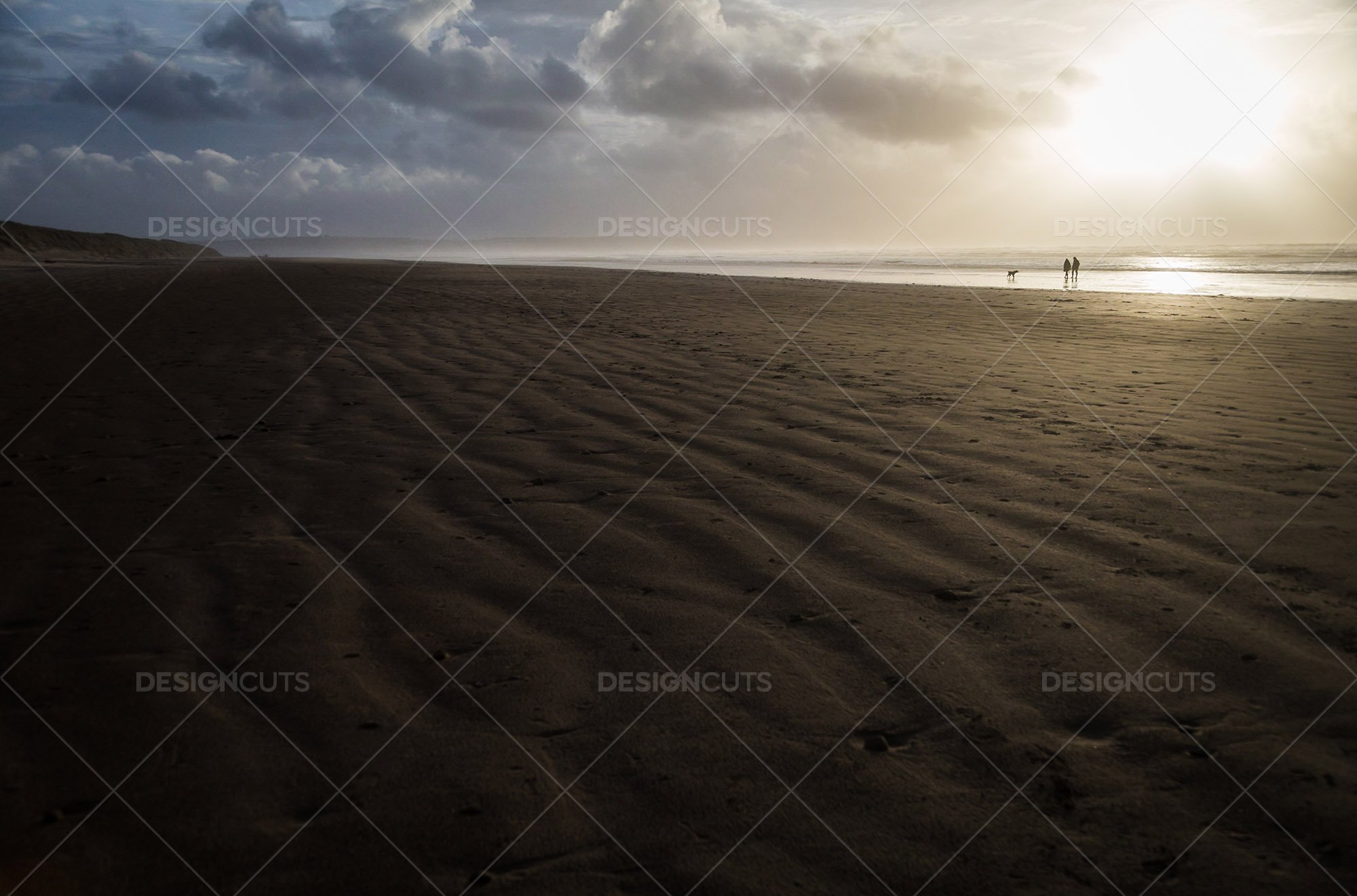 Two People Walking In The Distance On The Beach At Saunton Sands, Devon